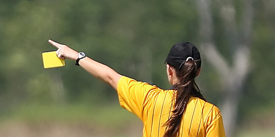Schiedsrichterin zeigt gelbe Karte