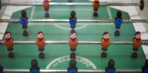 Ein halber Kickertisch mit Figuren von oben